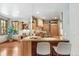Well-lit kitchen with wooden cabinets, granite counters, and an island with seating at 2411 S Garfield St, Denver, CO 80210