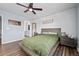 This bright bedroom features wood-look floors, light blue walls, ceiling fan, and cozy bed at 23500 E Alamo Pl # B19, Aurora, CO 80016