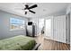 Bright bedroom with closet access, light blue walls, ceiling fan, wood-look floors, and comfy bed at 23500 E Alamo Pl # B19, Aurora, CO 80016