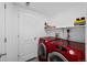 Practical laundry room with red, front-loading washer and dryer set at 23500 E Alamo Pl # B19, Aurora, CO 80016