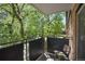 Balcony featuring black metal railings, chair, and views of lush green trees at 1201 Race St # 10, Denver, CO 80206