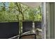Cozy balcony view with black metal railing and chairs overlooking lush green trees at 1201 Race St # 10, Denver, CO 80206