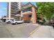A brick apartment building with balconies with white vehicles in the parking lot at 1201 Race St # 10, Denver, CO 80206