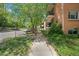 Street view of a brick apartment complex showing the sidewalk and greenery at 1201 Race St # 10, Denver, CO 80206