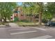 Street view of the building corner, highlighting crosswalks, street signage, trees, and building facade at 1201 Race St # 10, Denver, CO 80206
