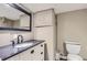 Bathroom featuring stone countertop vanity, dark framed mirror, and cabinet storage at 3930 S Sherman St, Englewood, CO 80113