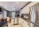 Bright kitchen with white cabinets, granite countertops, stainless steel dishwasher, and view to living area at 3930 S Sherman St, Englewood, CO 80113