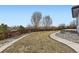 This backyard features a sprawling lawn, manicured landscaping, and a wooden fence at 10910 Touchstone Loop, Parker, CO 80134