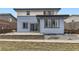 The back of this house has a well-manicured lawn, stone accents, and a patio area at 10910 Touchstone Loop, Parker, CO 80134
