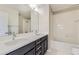 This bright bathroom features a double vanity, large mirror, and white subway tiled shower at 10910 Touchstone Loop, Parker, CO 80134