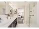 Bathroom featuring dual sinks, a large mirror, and a glass-enclosed shower at 10910 Touchstone Loop, Parker, CO 80134