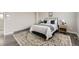 Well-lit bedroom with a comfortable bed, side tables, and a patterned rug on a hardwood floor at 10910 Touchstone Loop, Parker, CO 80134