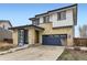 Two-story home with stone and siding, complemented by a blue garage door and trim at 10910 Touchstone Loop, Parker, CO 80134