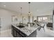 Open-concept kitchen with granite island, stainless sink, and adjacent dining area and living room at 10910 Touchstone Loop, Parker, CO 80134
