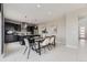 Open kitchen and dining area with a large island, dark cabinetry, and modern lighting at 10910 Touchstone Loop, Parker, CO 80134