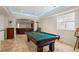 Finished basement featuring a pool table, travertine floors, and arched doorway to Gathering area at 14958 Wistera Way, Broomfield, CO 80023