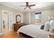 Bright bedroom showcasing a hardwood floor, natural light, and a wooden dresser at 14958 Wistera Way, Broomfield, CO 80023