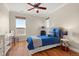 Cozy bedroom features hardwood floors, two large windows, and comfortable furnishings at 14958 Wistera Way, Broomfield, CO 80023