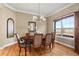 Formal dining room with a large window, elegant light fixture and views of the surrounding landscape at 14958 Wistera Way, Broomfield, CO 80023
