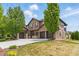Beautiful two-story home featuring a three-car garage, stone accents, and lush green lawn at 14958 Wistera Way, Broomfield, CO 80023