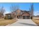Beautiful exterior of home with stone accents, manicured lawn, and three-car garage, adding curb appeal at 14958 Wistera Way, Broomfield, CO 80023
