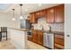 Open kitchen with stainless steel appliances, granite counters, and wood cabinets at 14958 Wistera Way, Broomfield, CO 80023
