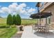 Inviting backyard patio with stone accents, featuring an outdoor table set and open space at 14958 Wistera Way, Broomfield, CO 80023