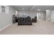 Spacious finished basement with leather recliners, neutral paint and carpet, art, and a nearby staircase at 23252 E Glidden Dr, Aurora, CO 80016