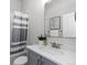 Well-lit bathroom featuring a shower with a stylish curtain and granite countertop at 23252 E Glidden Dr, Aurora, CO 80016
