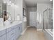 Bathroom featuring double sinks with white quartz countertops and a glass shower at 23252 E Glidden Dr, Aurora, CO 80016