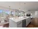Kitchen island featuring quartz countertops, pendant lighting, and open layout to the living and dining area at 23252 E Glidden Dr, Aurora, CO 80016