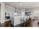 Modern kitchen with stainless steel appliances, large island with seating, and dark hardwood floors at 23252 E Glidden Dr, Aurora, CO 80016