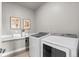 Functional laundry room with new Samsung washer and dryer, folding counter, decor art, and neutral paint at 23252 E Glidden Dr, Aurora, CO 80016