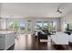Open floor plan featuring a kitchen, living room, and dining area filled with natural light and hardwood floors at 23252 E Glidden Dr, Aurora, CO 80016