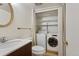 Bathroom featuring vanity with sink, toilet, and in-unit laundry at 6650 E Arizona Ave # 203, Denver, CO 80224