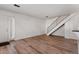 Open-concept living room with wood floors, white walls, and staircase at 6650 E Arizona Ave # 203, Denver, CO 80224