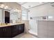 Beautiful bathroom featuring a glass shower with built-in shelving and double sinks at 4834 S Wenatchee St, Aurora, CO 80015