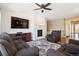 Comfortable living room with a fireplace, ceiling fan and dark grey furniture on a patterned rug at 4834 S Wenatchee St, Aurora, CO 80015