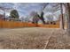 Large backyard with wooden fence, grass, and some leaf litter at 12866 E Ohio Ave, Aurora, CO 80012