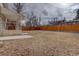 Backyard with wooden fence, grass, and steps leading to a patio at 12866 E Ohio Ave, Aurora, CO 80012