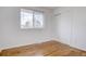 Simple bedroom with hardwood floors and large window at 12866 E Ohio Ave, Aurora, CO 80012