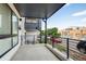 Balcony with black metal railing offering street views under a partly cloudy sky at 2400 S Delaware St # 1, Denver, CO 80223