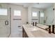 Modern bathroom with double sinks, marble accents, sleek fixtures, and glass-enclosed shower for a spa-like retreat at 2400 S Delaware St # 1, Denver, CO 80223