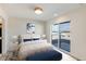 Serene bedroom featuring a plush bed, contemporary design, and sliding doors leading to a balcony with city views at 2400 S Delaware St # 1, Denver, CO 80223