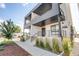 Modern condo exterior with balcony, black railings, and well-maintained landscaping at 2400 S Delaware St # 1, Denver, CO 80223