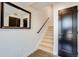 Bright condo hallway with wood floors, staircase, mirror, and dark door at 2400 S Delaware St # 1, Denver, CO 80223