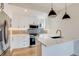 Bright kitchen features stainless steel appliances, white cabinets, a center island, and a stylish backsplash at 2400 S Delaware St # 1, Denver, CO 80223
