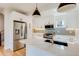 Bright kitchen featuring stainless steel appliances, quartz countertops, and sleek white cabinetry at 2400 S Delaware St # 1, Denver, CO 80223