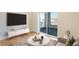 Bright living room with hardwood floors, modern furniture, and large sliding doors leading to a balcony with views at 2400 S Delaware St # 1, Denver, CO 80223