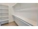 Clean and bright walk-in closet with built-in shelves and hanging rack perfect for storage at 2400 S Delaware St # 1, Denver, CO 80223